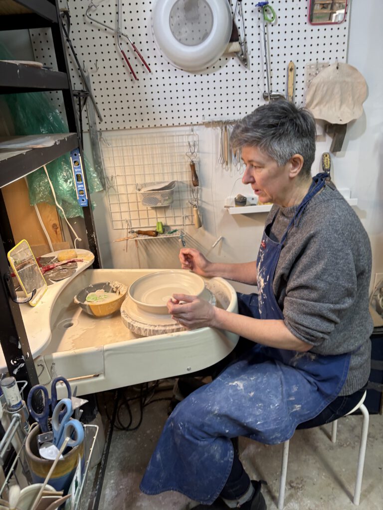 Sophie sitting at the pottery wheel