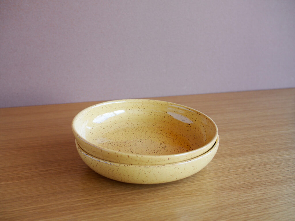 Two stacked yellow pasta plates